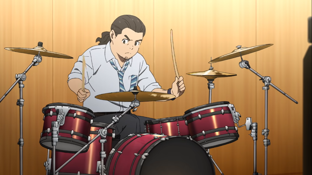 Michi, memainkan drum.